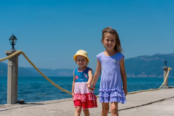 Sahilde yürüyen küçük kız kardeşler — Stok fotoğraf