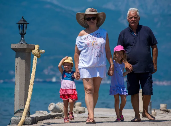 Grootouders en kleindochters wandelen door de zee — Stockfoto