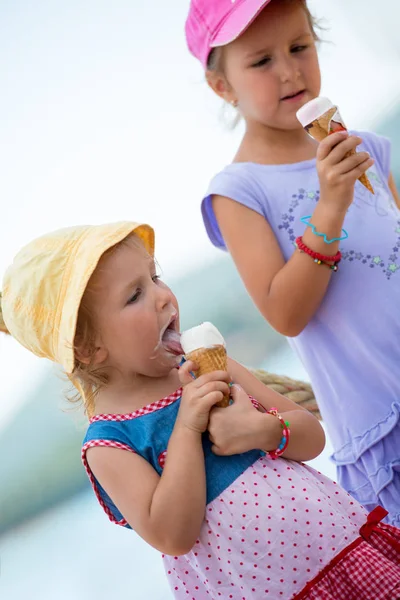 Little girls eating ice cream by the sea — Stock Photo, Image