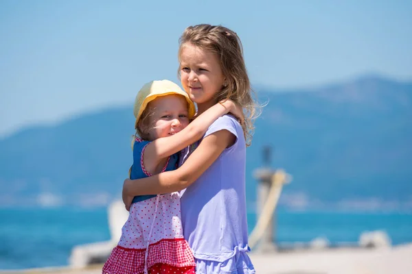 Little sisters hugging on the beach coast — Stock Photo, Image