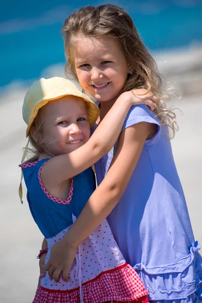 Little sisters hugging on the beach coast — Stock Photo, Image