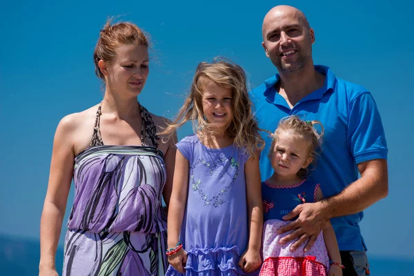 Retrato de la joven familia feliz con hijas junto al mar —  Fotos de Stock