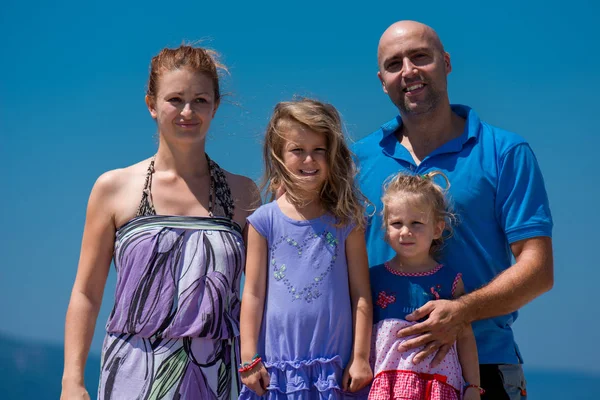 Retrato de la joven familia feliz con hijas junto al mar —  Fotos de Stock