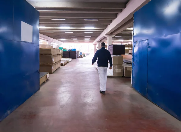 Carpinteiro andando através da fábrica — Fotografia de Stock