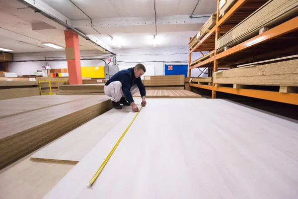 Carpenter measuring wooden board — Stock Photo, Image