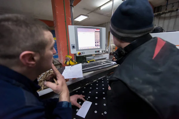 Carpentieri calcolando e programmando una macchina per la lavorazione del legno CNC — Foto Stock