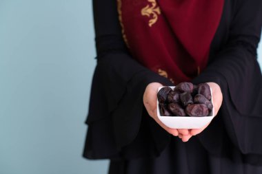 ramazan kareem 'de bir tabak hurma tutan modern Müslüman kadın.