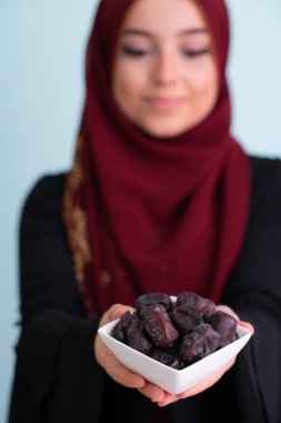 ramazan kareem 'de bir tabak hurma tutan modern Müslüman kadın.