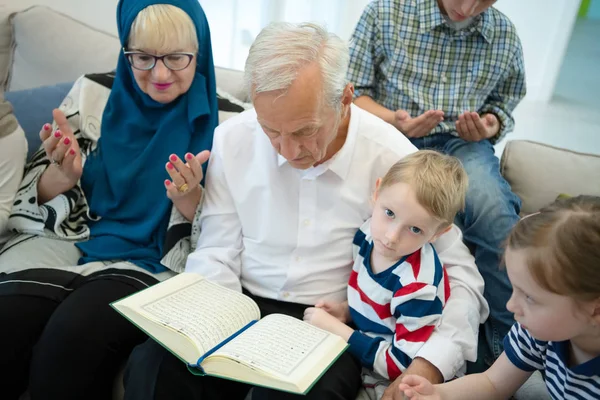 Modernos avós muçulmanos com netos lendo Alcorão — Fotografia de Stock