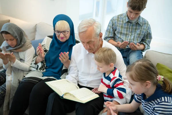 Modernos avós muçulmanos com netos lendo Alcorão — Fotografia de Stock