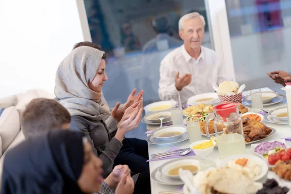 Moderna família muçulmana multiétnica rezando antes de ter iftar din — Fotografia de Stock