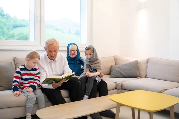 Abuelos musulmanes modernos con nietos leyendo el Corán —  Fotos de Stock