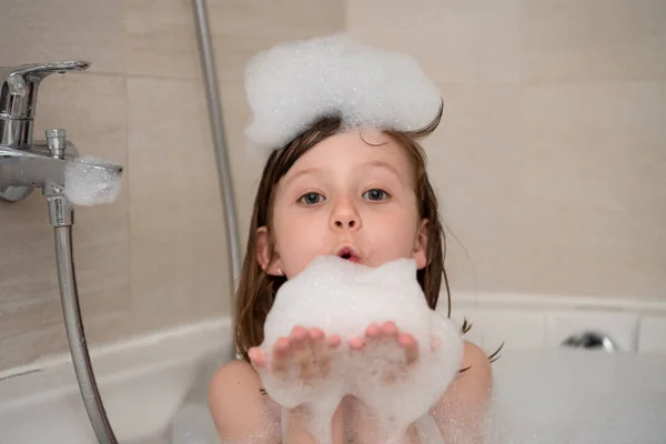 Little girl in bath playing with foam — Stock Photo, Image