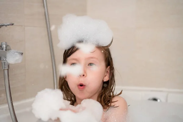 Petite fille dans le bain jouer avec la mousse — Photo