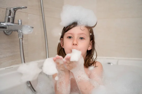 Kleines Mädchen in der Badewanne spielt mit Schaum — Stockfoto