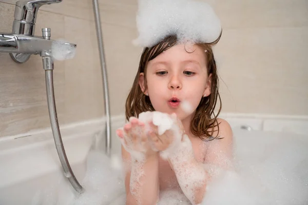 Маленька дівчинка в ванні грає з піною — стокове фото