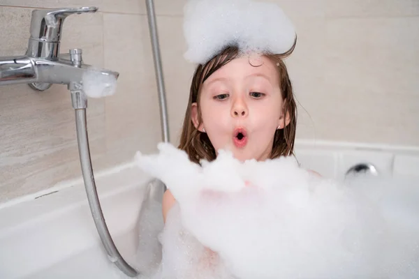 Kleines Mädchen in der Badewanne spielt mit Schaum — Stockfoto