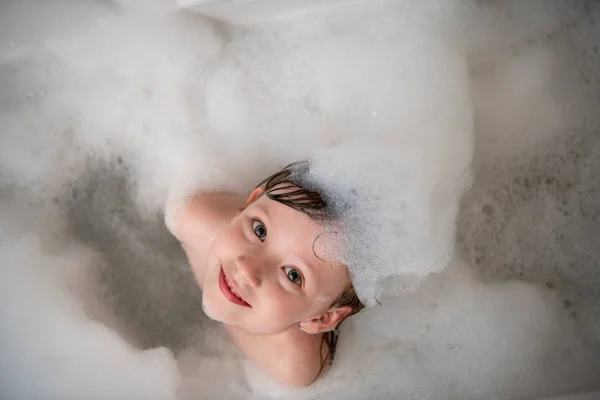 Vue du dessus de la petite fille dans le bain jouant avec la mousse — Photo