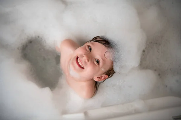 Top view of little girl in bath playing with foam — Stock Photo, Image