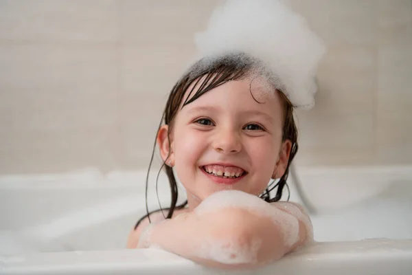 Petite fille dans le bain jouer avec la mousse — Photo
