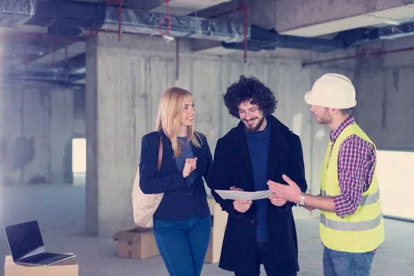 Architect showing house design plans to a young couple — Stock Photo, Image