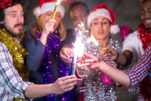 Multiethnic group of casual business people lighting a sparkler — Stock Photo, Image