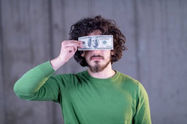 gözleri üzerinde amerikan doları banknot tutan iş adamı
