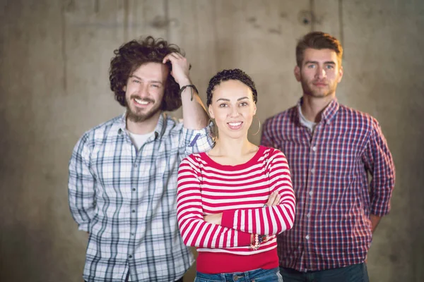 Portrait of casual business team in front of a concrete wall — Stock Photo, Image