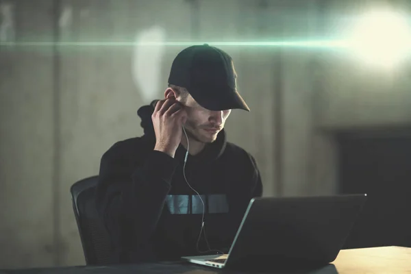 Young talented hacker using laptop computer while working in dar — Stock Photo, Image