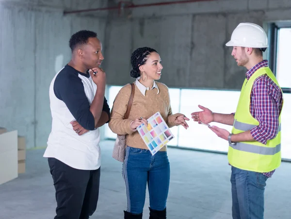 Architekt zeigt jungen multiethnischen Putschisten Hauspläne — Stockfoto