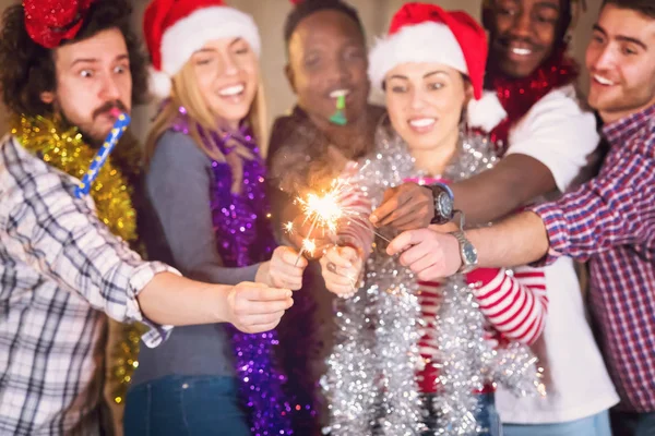 Multiethnic group of casual business people lighting a sparkler — Stock Photo, Image