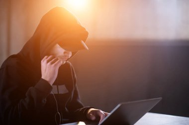 dar çalışırken dizüstü bilgisayar kullanarak genç yetenekli hacker