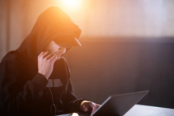 Young talented hacker using laptop computer while working in dar — Stock Photo, Image