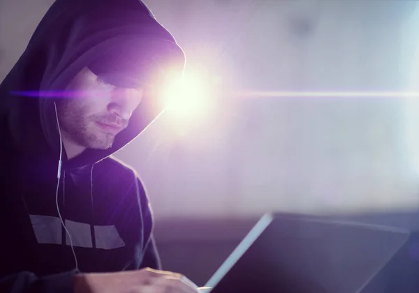 Young talented hacker using laptop computer while working in dar — Stock Photo, Image