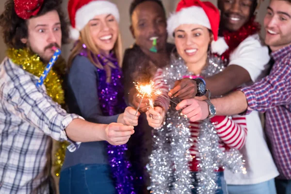 Multiethnic group of casual business people lighting a sparkler — Stock Photo, Image