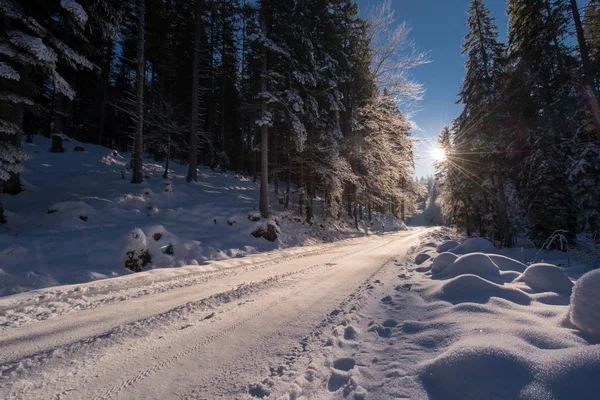 Verschneite Landstraße bei Sonnenuntergang oder Sonnenaufgang — Stockfoto