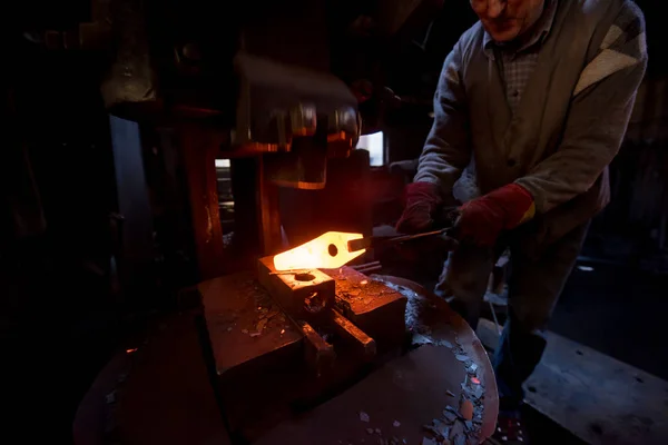 Herrero forjando manualmente el metal fundido —  Fotos de Stock