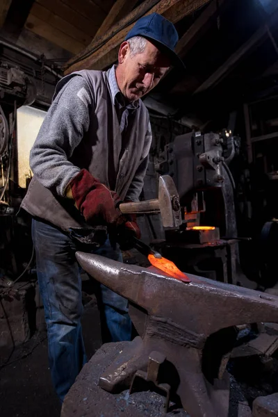 Fabbro forgiare manualmente il metallo fuso — Foto Stock