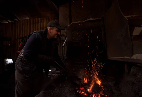 Jovem Blacksmith tradicional trabalhando com fogo aberto — Fotografia de Stock