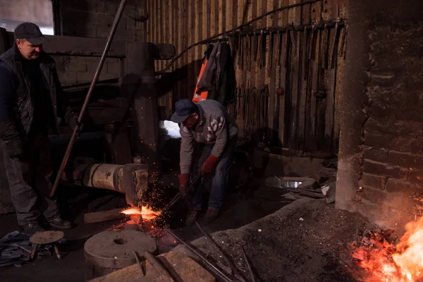 Smid arbeiders met behulp van mechanische hamer op de werkplaats — Stockfoto