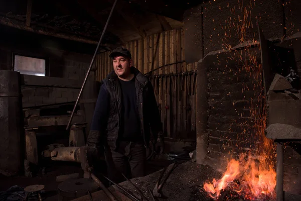 若い伝統的な鍛冶屋オープン火災で作業 — ストック写真