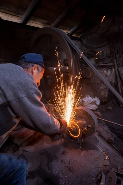 Demirci metal ürünlerini parlatıyor. — Stok fotoğraf