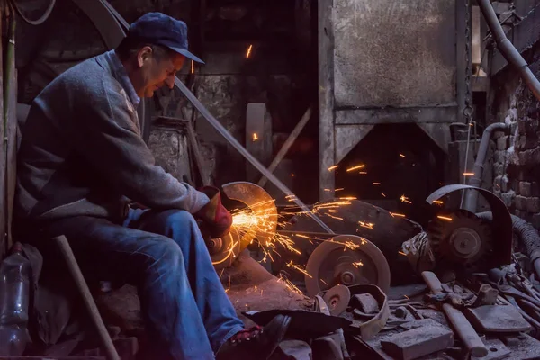 Demirci metal ürünlerini parlatıyor. — Stok fotoğraf