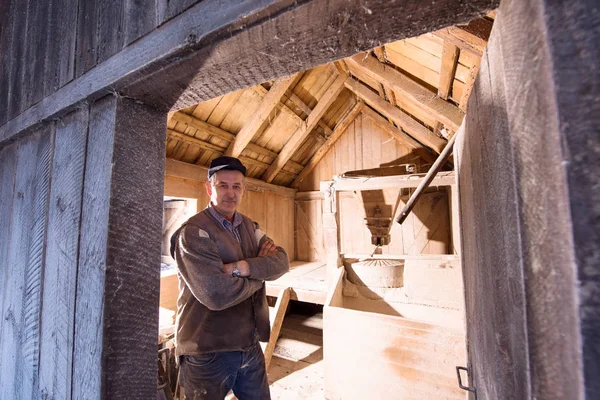 Portret van een molenaar in retro houten watermolen — Stockfoto