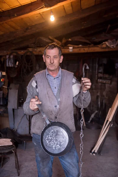 Працівник коваля, який демонструє готові до продажу вироби ручної роботи — стокове фото