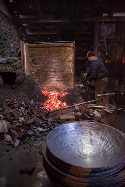 Jovem Blacksmith tradicional trabalhando com fogo aberto — Fotografia de Stock