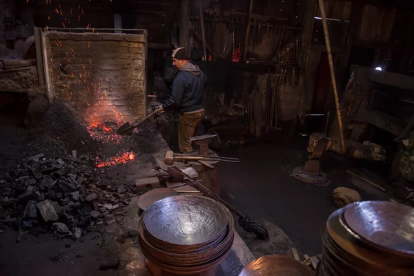 Jovem Blacksmith tradicional trabalhando com fogo aberto — Fotografia de Stock