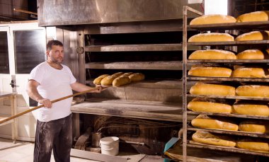 fırın işçisi taze pişmiş ekmek alarak