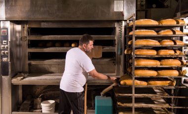 fırın işçisi taze pişmiş ekmek alarak