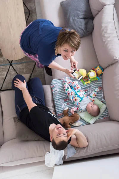 Von oben: glückliche Mutter und Vater beim Fotografieren des Babys — Stockfoto